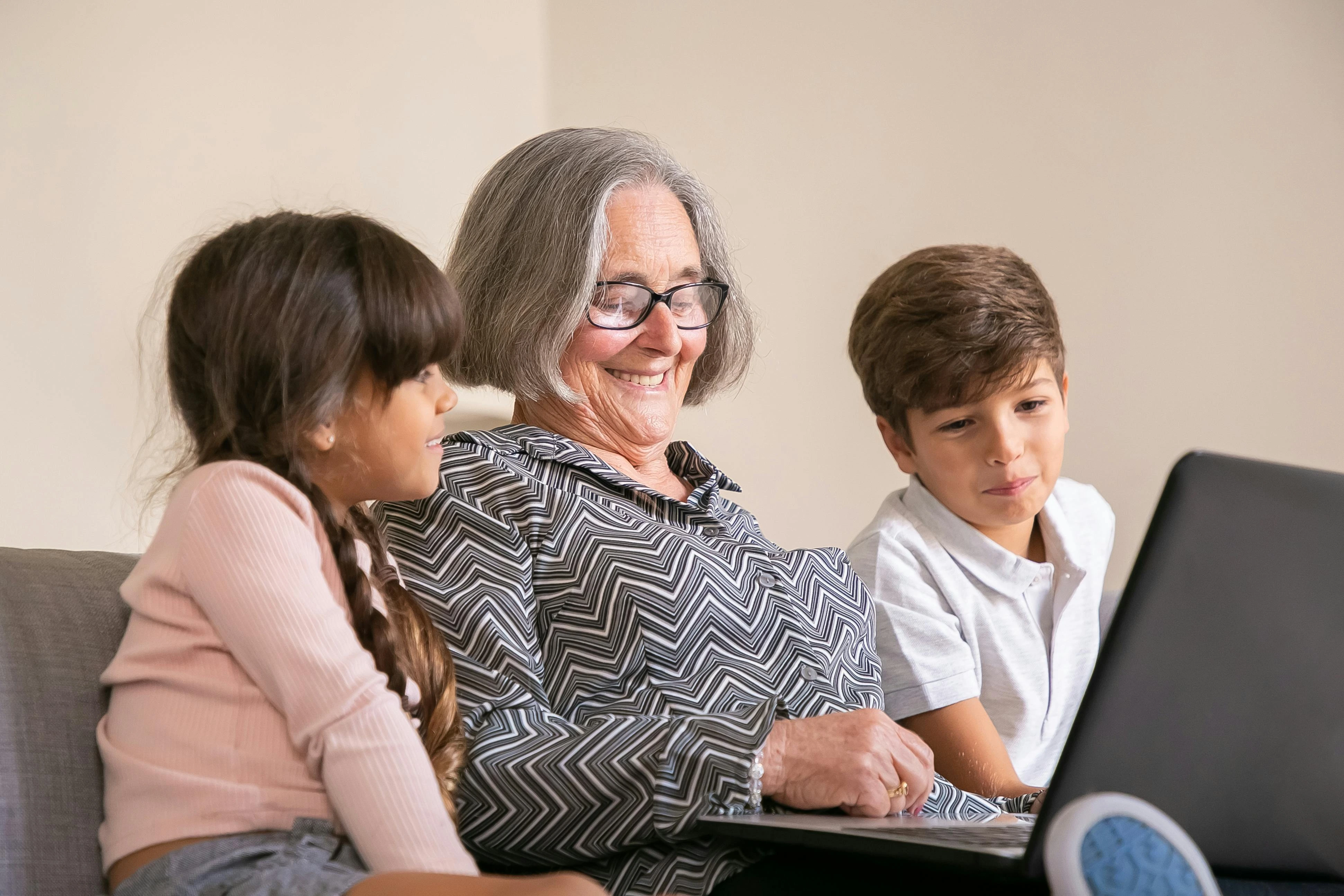 Family gathered around a laptop, viewing a memorial page